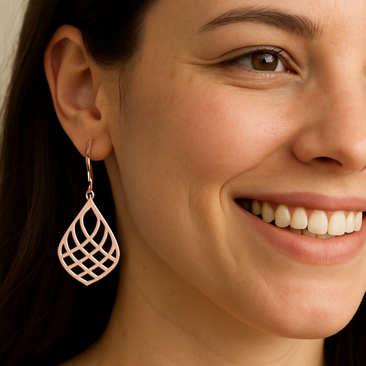 Close-up of a woman wearing handmade 925 sterling silver teardrop earrings with a geometric cutout design