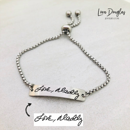 Adjustable stainless steel bracelet engraved with a handwritten message.