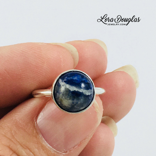 Natural blue stone ring featuring a 10mm sodalite gemstone set in genuine 925 sterling silver, highlighting the stone's distinctive color in this finished US size 6 ring for artists and creative thinkers.