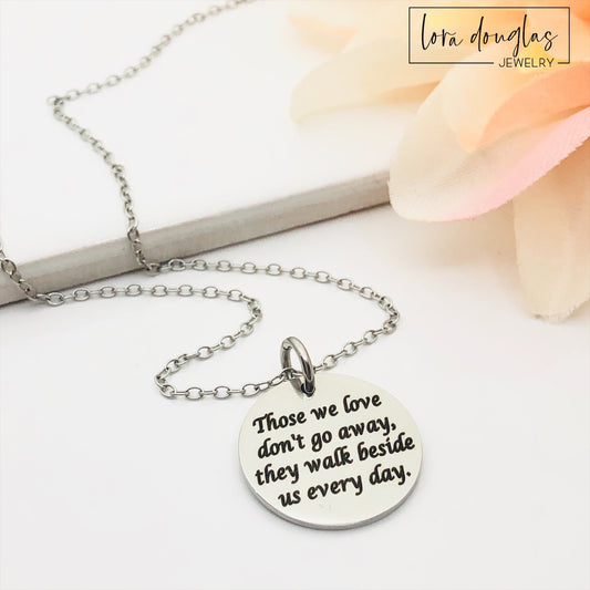 Silver necklace with a round pendant on a white background. Engraved with Those We Love Don't Go Away They Walk Beside Us Every Day.