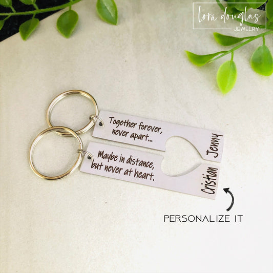 A stainless steel heart-shaped keychain with engraved text 'Together Forever Never Apart Maybe in Distance but Never at Heart' The keychain is silver-colored and has a personalized engraving.