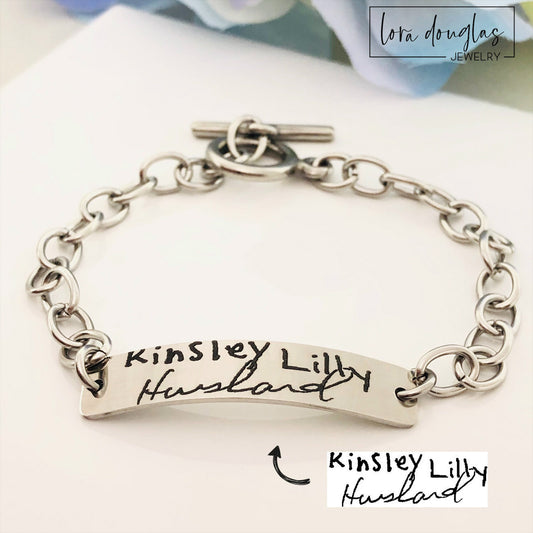 A stainless steel bracelet with engraved handwriting
