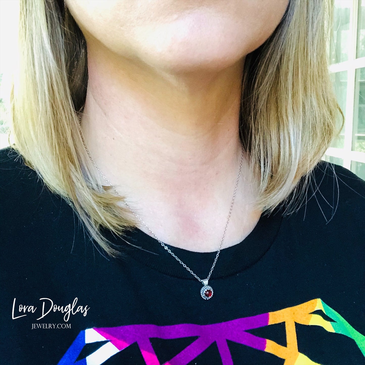 A sterling silver pendant necklace with a turquoise stone, displayed on a silver chain.