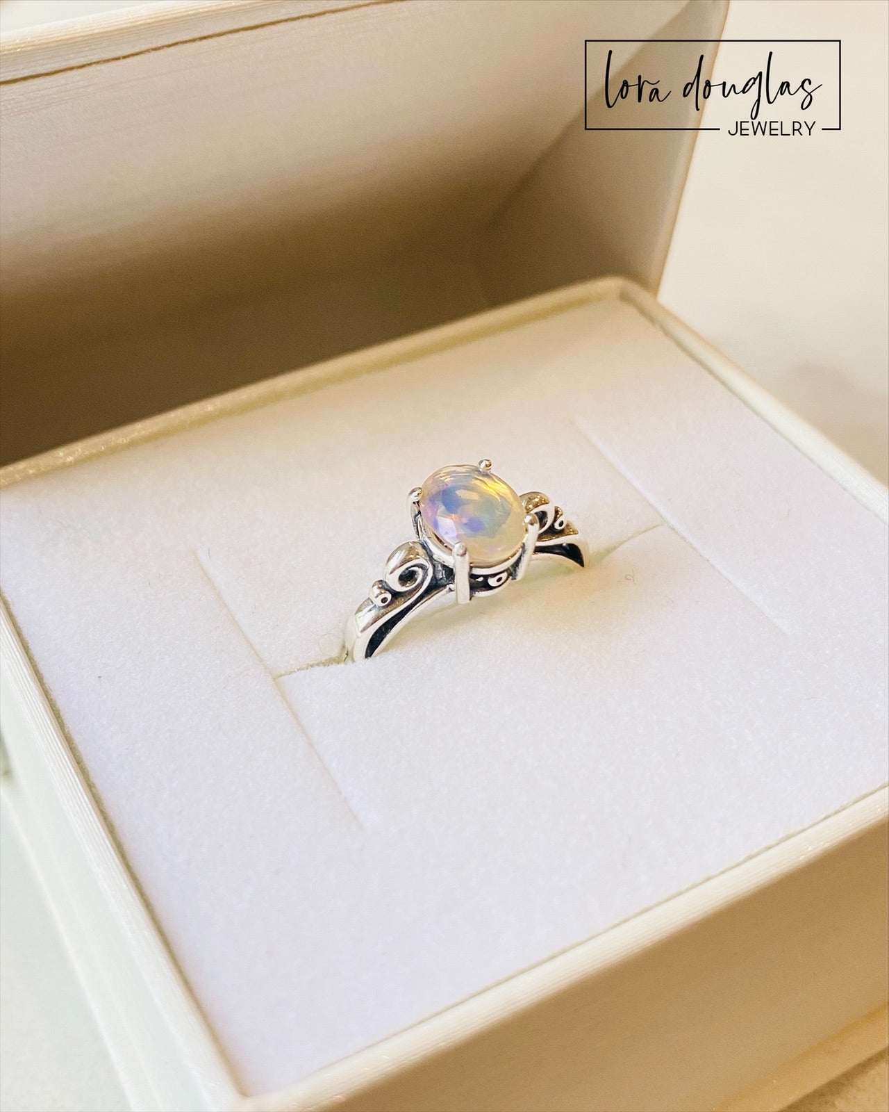 A sterling silver ring with a central opal stone