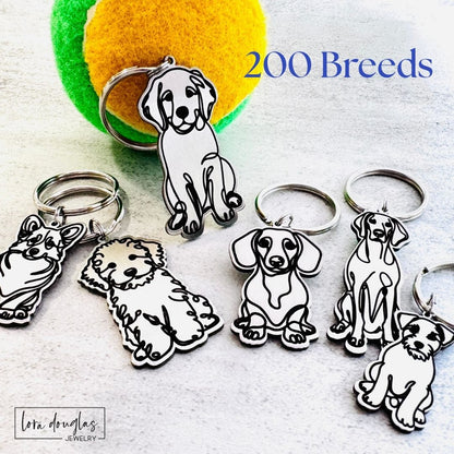 Custom dog breed keychains made from stainless steel featuring engraved dog breed illustrations for personalized dog lover gifts.