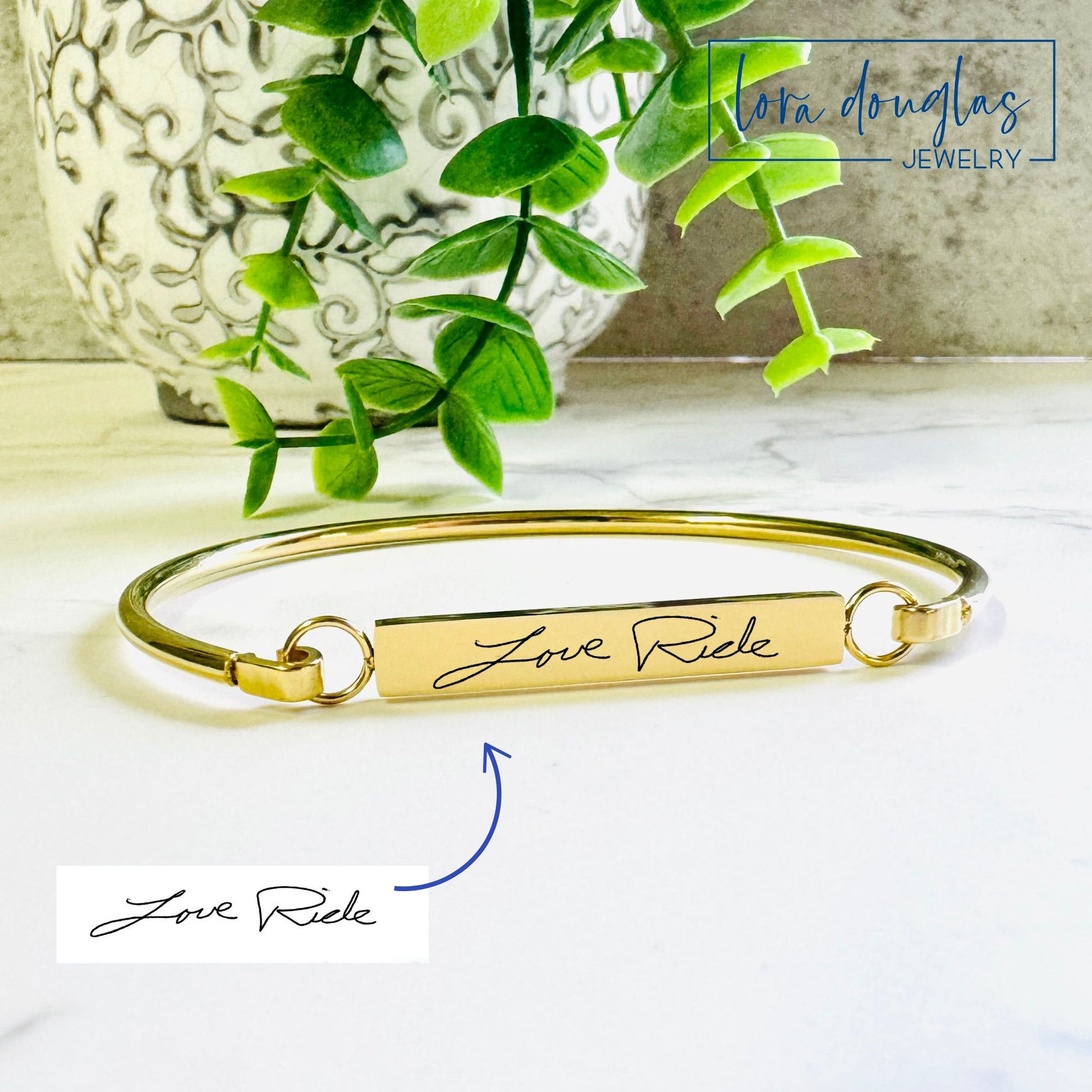 A gold  bangle bracelet with the engraved handwriting 