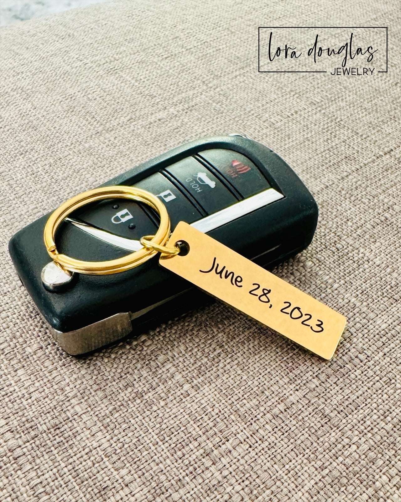 A gold stainless steel keychain with an custom engraved text