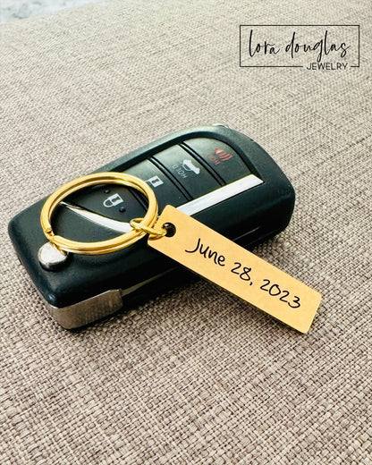 A gold stainless steel keychain with an custom engraved text