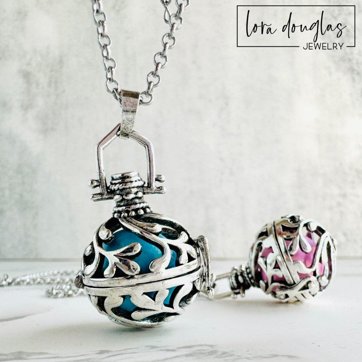 A silver rolo chain necklace with a lobster clasp, featuring a chime pendant with a silver design. The pendant has a textured surface and can be adorned with a Swarovski birthstone charm.