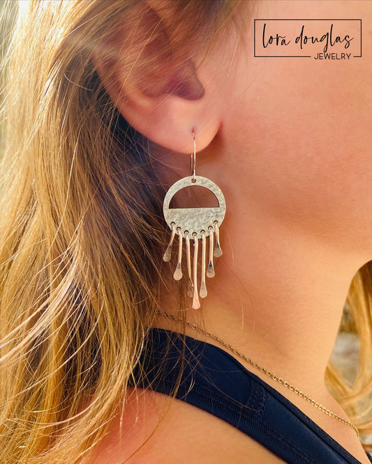 Artisan sterling silver earrings with dangling wind chime inspired details and silver ear wires, measuring approximately 2.5 inches long for a noticeable yet lightweight statement jewelry design.
