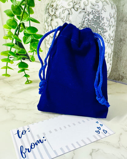Blue drawstring bag on a marble surface with a decorative card.