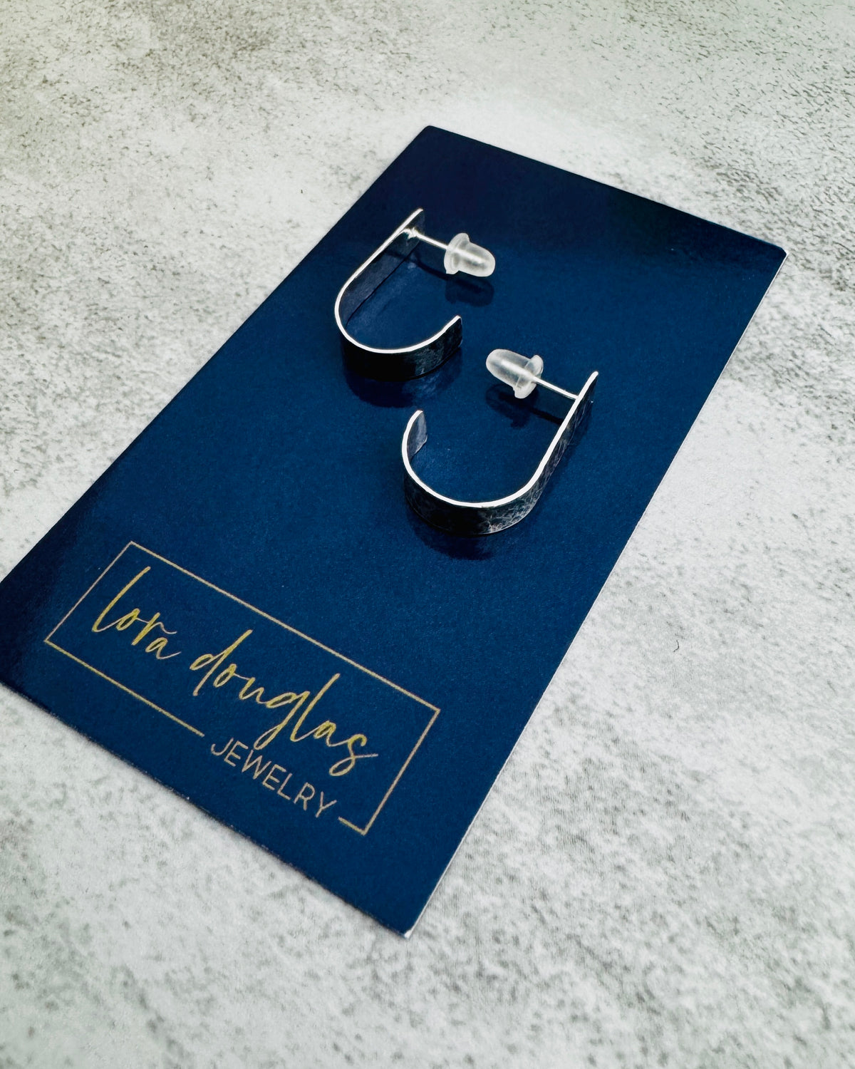 Classic sterling silver earrings featuring a textured hoop design that reflects light across the surface, sized at approximately 22mm for shoppers searching for versatile silver jewelry and comfortable daily earrings.
