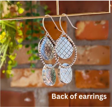 Close view of howlite and amazonite earrings worn on the ear, showing the natural gray veining in the white howlite and soft aqua green coloring of the amazonite in polished sterling silver settings.
