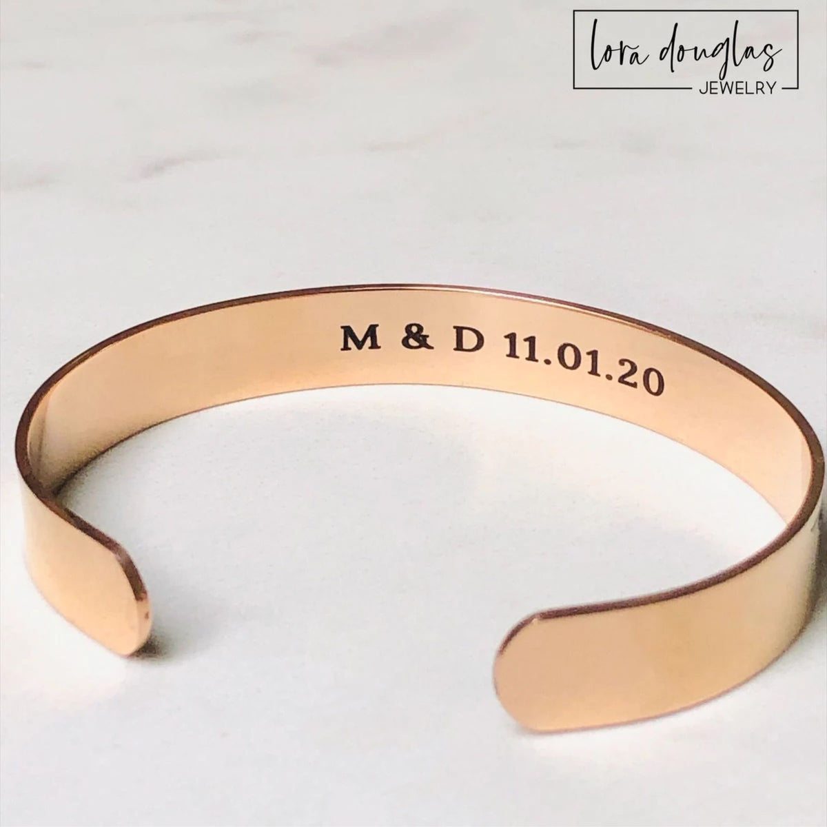 Custom secret message bracelet showing personalized black laser engraving inside a polished stainless steel cuff, designed for a private quote, meaningful date, coordinates, initials or personal message.