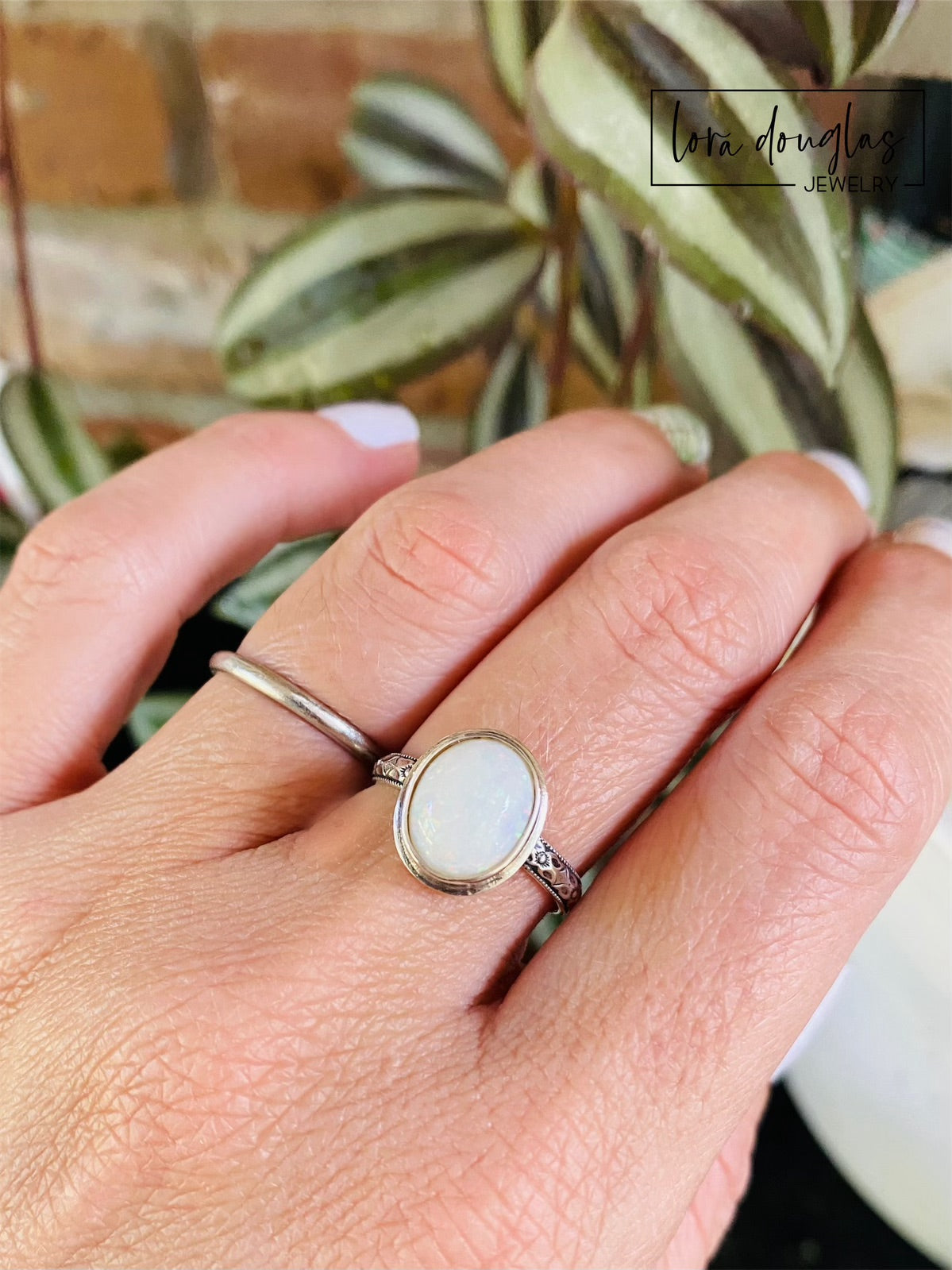 Detailed view of a hand cut oval opal cabochon in a sterling silver bezel setting, showing the 10mm x 12mm gemstone within an 11mm x 13.5mm setting on this handcrafted US size 7.75 ring.
