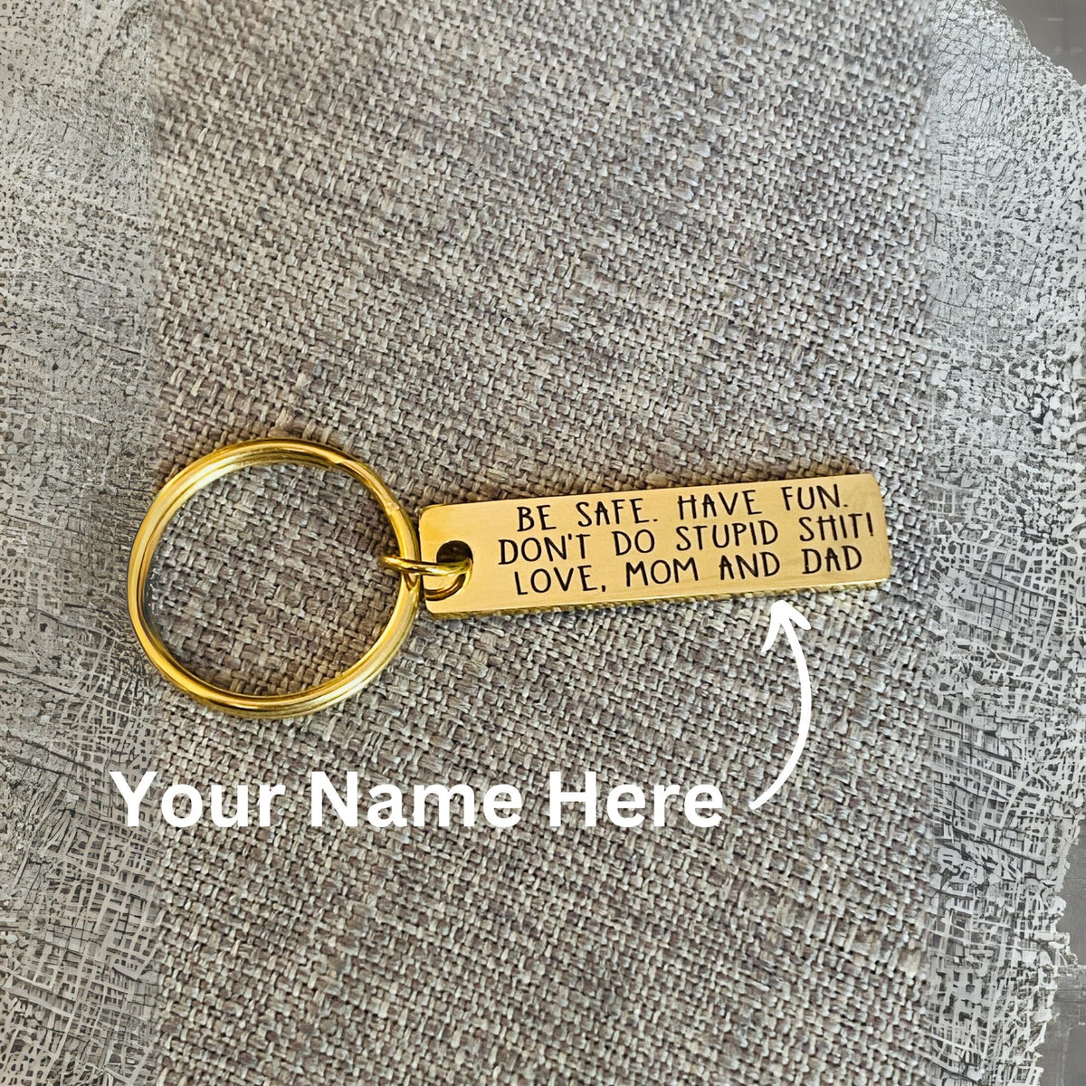 Gold personalized keychain with permanent laser engraving reading Don't Do Stupid Shit and a custom name, designed as a funny yet practical gift for a new driver, daughter, son, graduate or college student.
