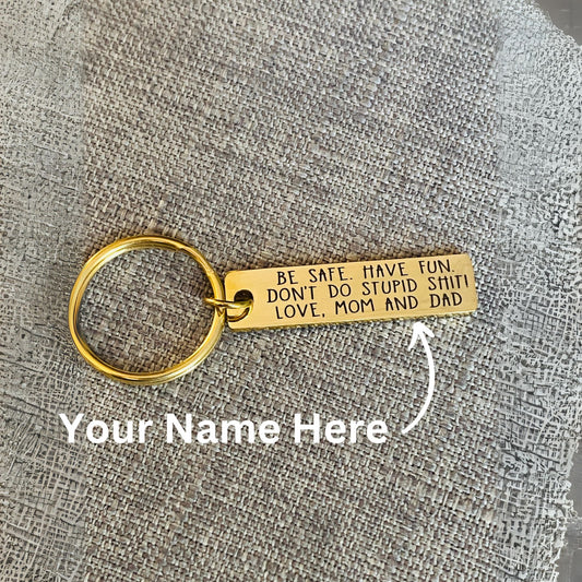 Gold personalized keychain with permanent laser engraving reading Don't Do Stupid Shit and a custom name, designed as a funny yet practical gift for a new driver, daughter, son, graduate or college student.
