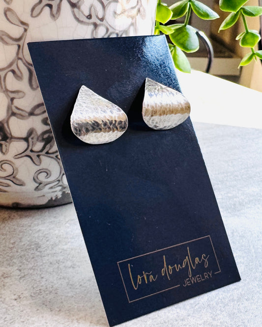 Hammered sterling silver stud earrings featuring an organic teardrop shape and subtle textured finish, handmade in the USA from solid 925 silver for a lightweight everyday jewelry design with modern character.
