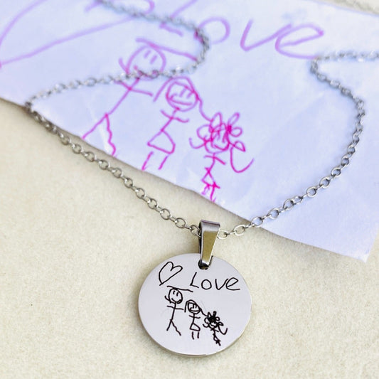Handmade handwriting jewelry engraved from an uploaded signature or handwritten message on a polished round pendant. Custom memorial necklace designed to preserve meaningful memories in sterling silver or stainless steel.