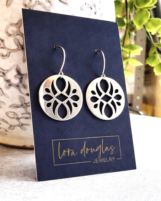 Handmade sterling silver disc earrings featuring an intricate cutout pattern in round 7/8 inch dangles, designed as lightweight artisan earrings for shoppers looking for distinctive everyday silver jewelry.

