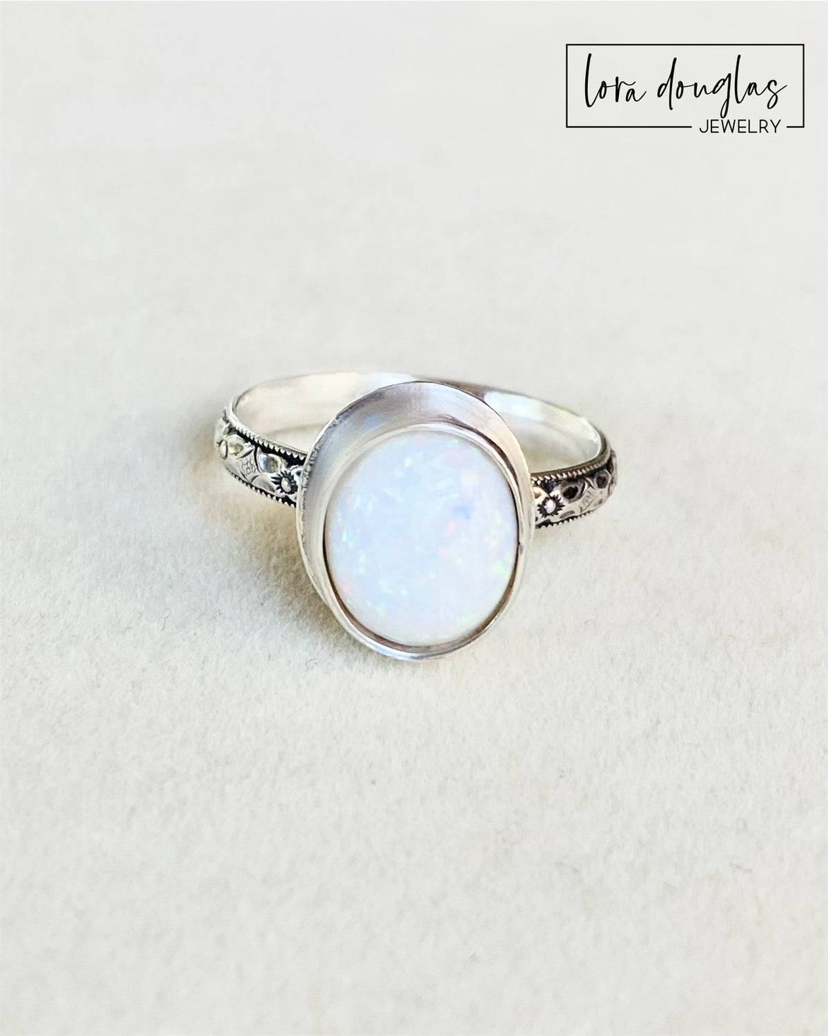Handmade sterling silver ring featuring a 10mm x 12mm hand cut opal cabochon in an 11mm x 13.5mm oval bezel setting, finished in US size 7.75 for shoppers seeking handcrafted gemstone jewelry.
