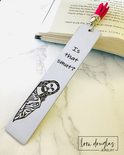 A stainless steel bookmark with  a leather tassel, featuring a laser engraving of a Jesus character with the text Is that Smut?