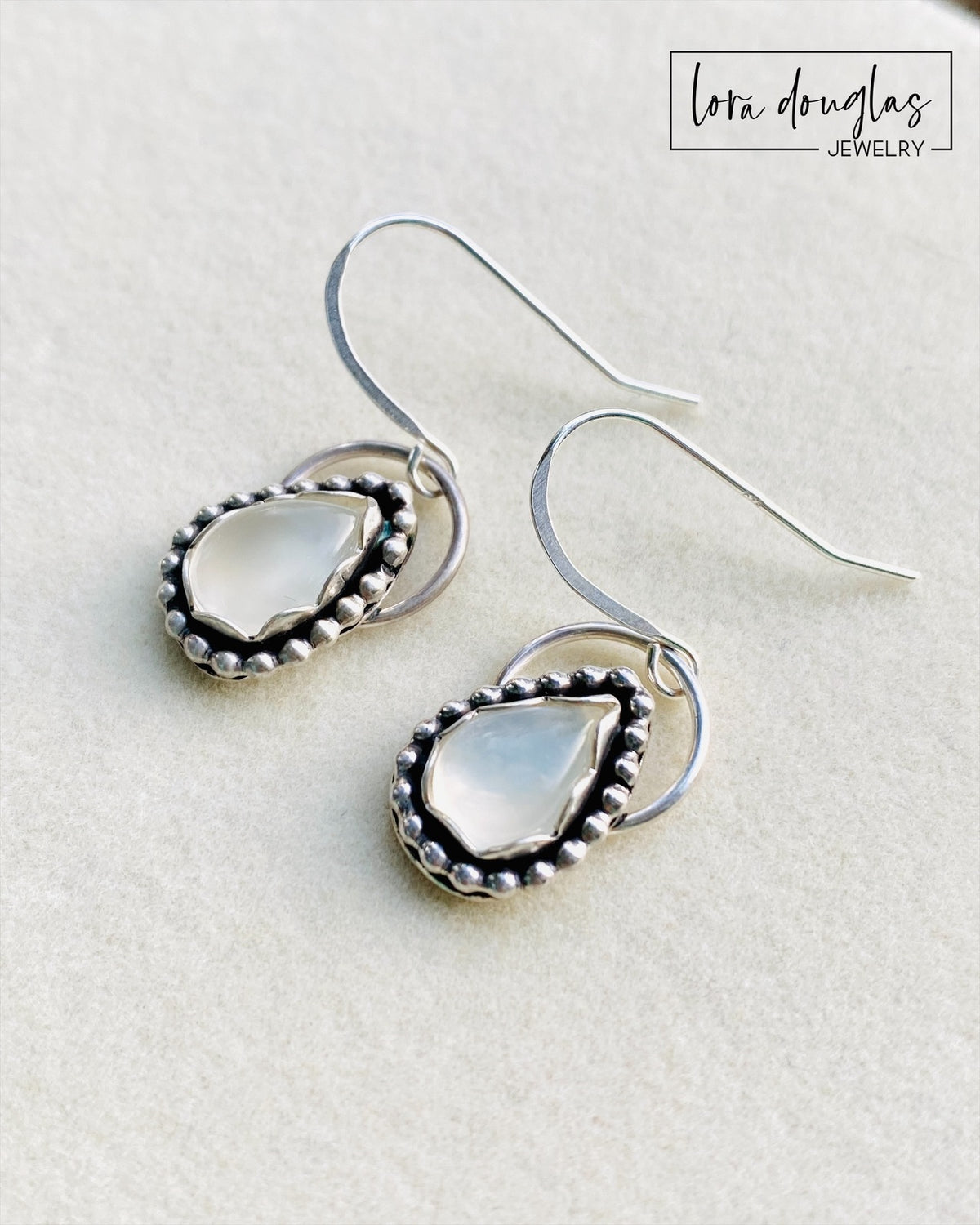 Natural moonstone earrings in sterling silver showcasing the gemstone's subtle coloring and individual variation, a versatile pair of silver gemstone earrings for everyday wear or June birthday gifting.
