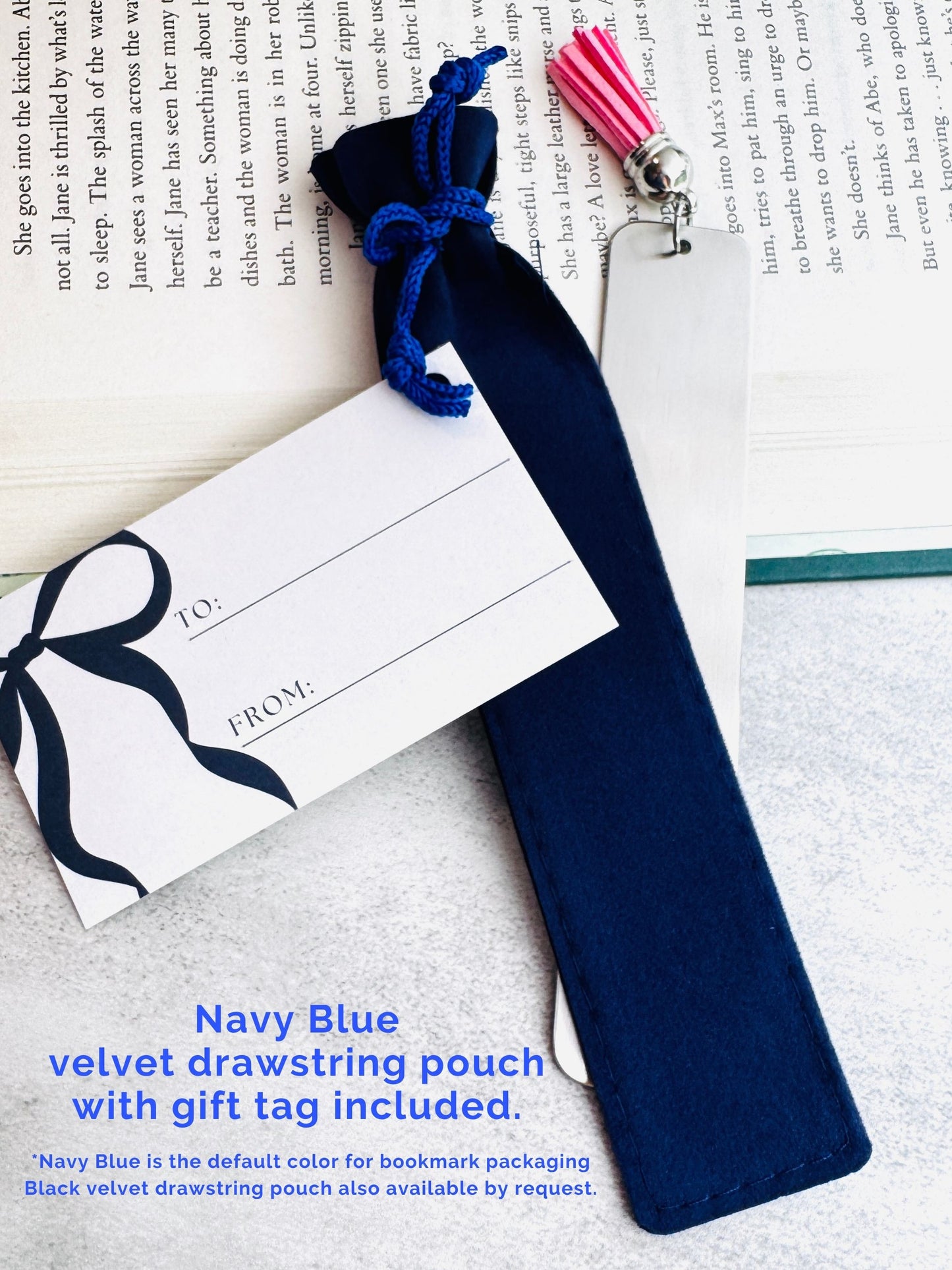 Navy blue velvet drawstring pouch with gift tag on a book