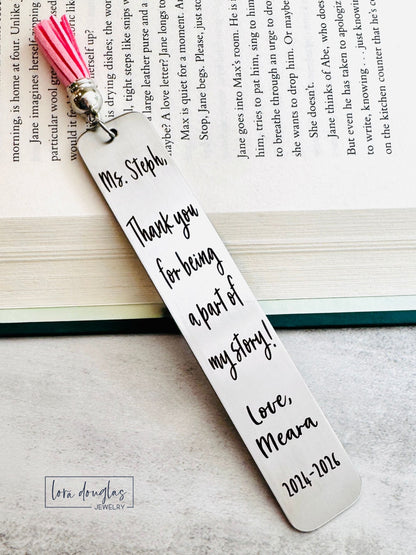 Personalized bookmark with pink tassel on a book