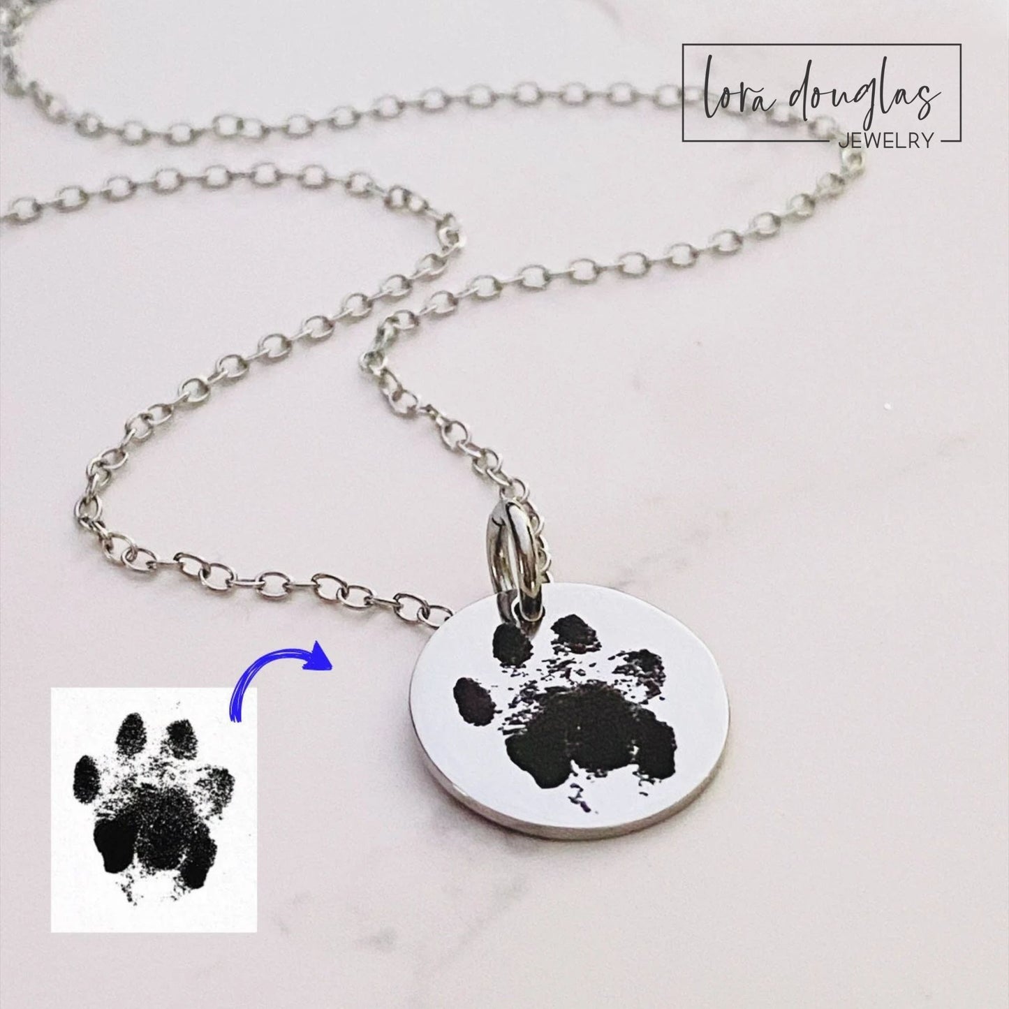 Personalized dog paw print necklace engraved with your pet's actual paw print on a stainless steel round pendant. Custom pet memorial jewelry available in silver, gold, and rose gold as a meaningful keepsake for dog lovers.