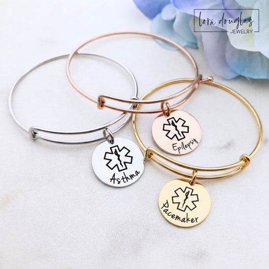Personalized medical alert bangle bracelet with round stainless steel pendant custom engraved with medical information, available in silver, gold or rose gold and your choice of 3/4 inch, 7/8 inch or 1 inch charm.
