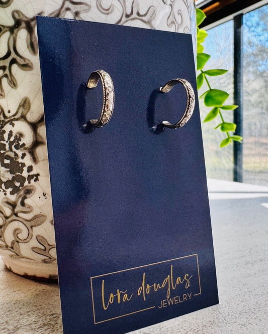 Petite sterling silver hoop earrings measuring approximately 1/2 inch in diameter, featuring 925 silver hoops and posts with clear earring backs for a classic everyday jewelry style.

