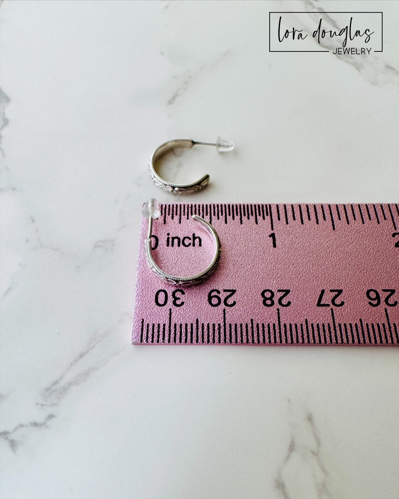 Petite sterling silver hoops featuring a traditional rounded silhouette and 1/2 inch diameter, a versatile pair of small post earrings for shoppers who prefer simple, timeless silver jewelry.
