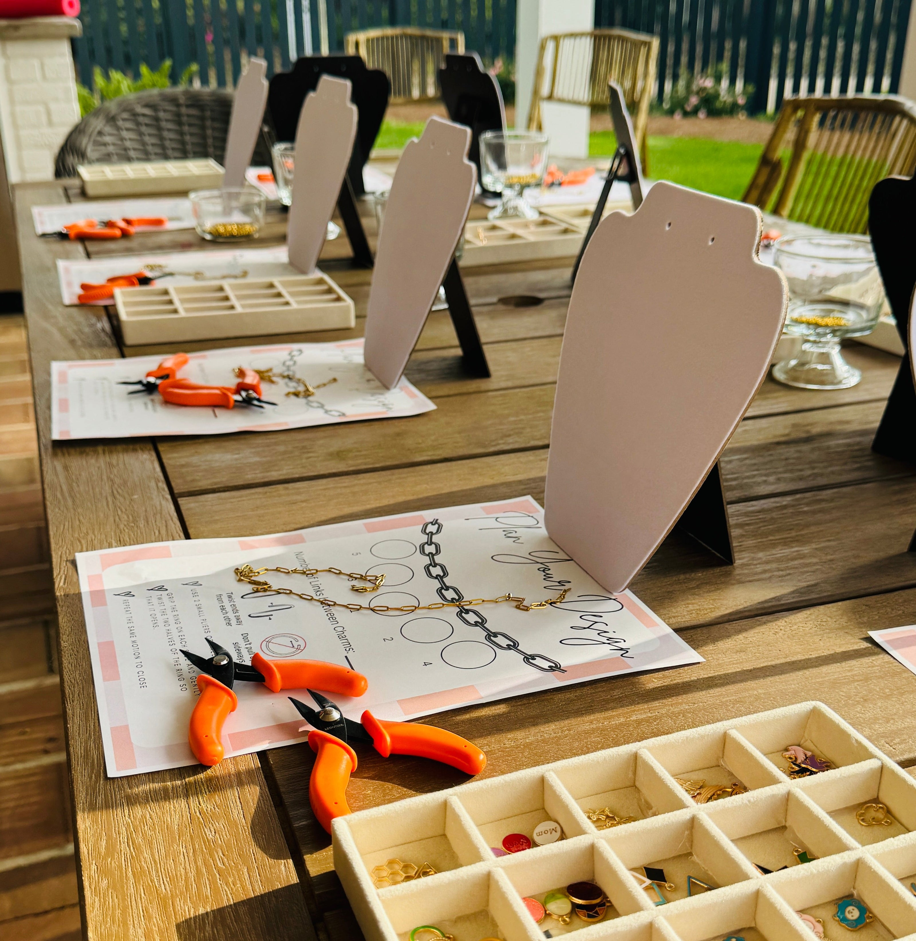Jewelry-making setup on a wooden table with tools and materials.
