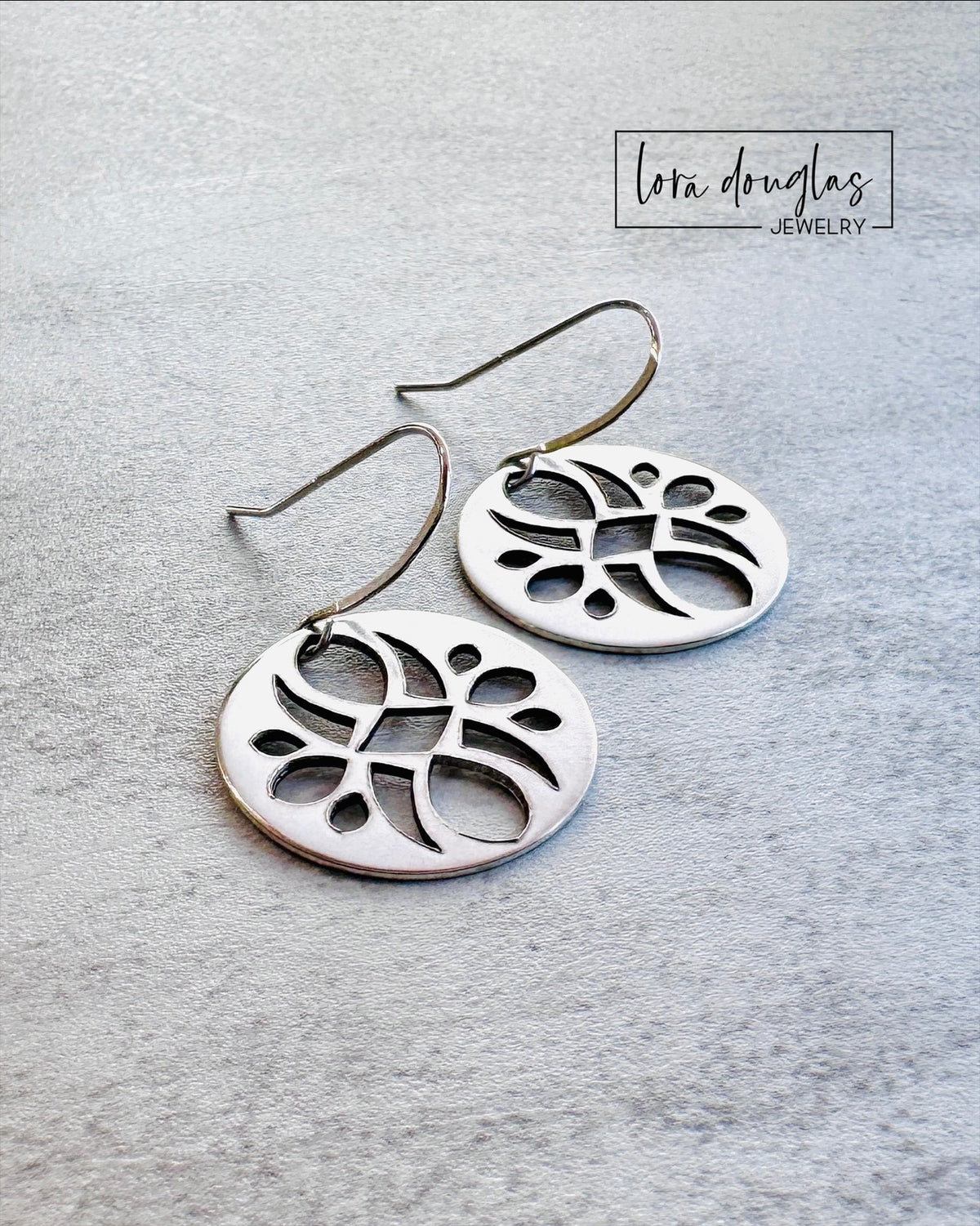 Round sterling silver dangle earrings featuring an intricate cutout design that creates texture and open space, handmade with 7/8 inch discs for shoppers seeking artistic statement jewelry that remains easy to wear.
