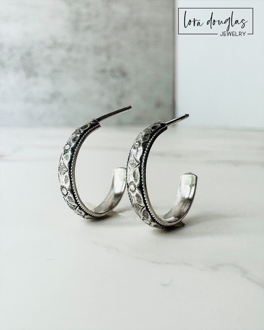 Small sterling silver hoop earrings featuring a classic rounded shape and petite 1/2 inch diameter, made from 925 silver with post closures for shoppers looking for simple, versatile everyday earrings.

