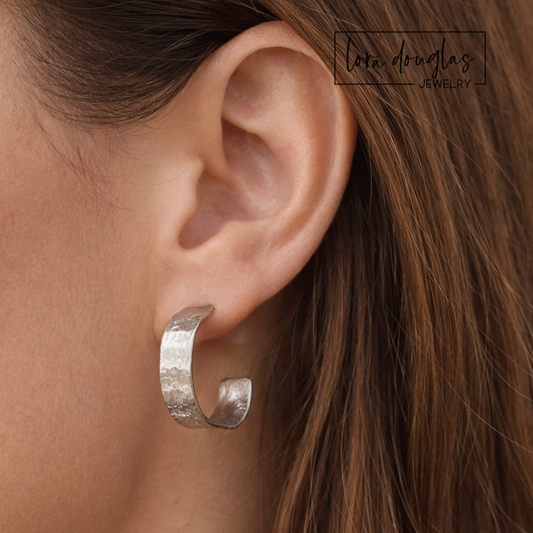 Small sterling silver hoop earrings featuring a subtle hammered texture that catches the light, designed as lightweight everyday silver earrings for shoppers looking for classic hoops with artisan detail.
