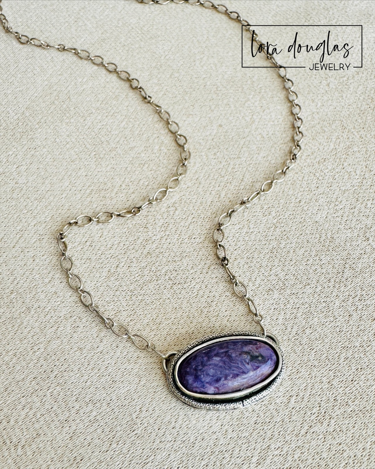 Sterling silver charoite pendant necklace showcasing a natural purple gemstone in a 23mm x 14.5mm oval shape, a distinctive jewelry design for shoppers who love purple stones and natural gemstone jewelry.
