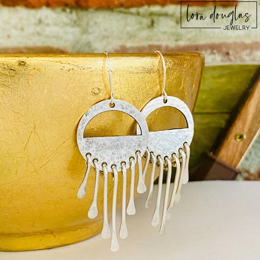 Sterling silver wind chime earrings featuring multiple dangling silver elements that create movement and texture, handcrafted as lightweight 2.5 inch dangle earrings for shoppers looking for distinctive artisan jewelry.
