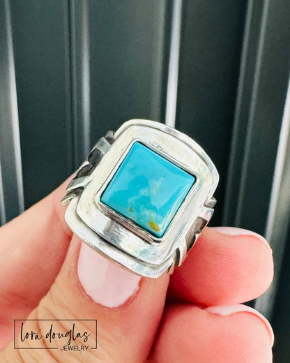artisan sterling silver ring with natural color Kingsman Turquoise gemstone, 10mm square stabilized turquoise cabochon set in a handcrafted saddle ring with layered silver details and substantial profile