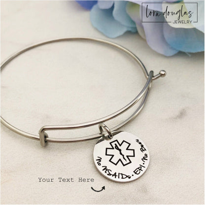 close up of custom engraved medical ID pendant showing medical alert symbol and personalized text on polished stainless steel disc necklace, durable medical alert jewelry for daily identification and peace of mind