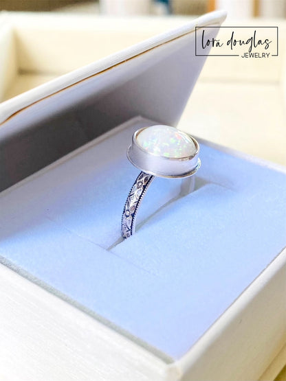 A sterling silver ring with a hand-cut opal cabochon centerpiece, set in an oval setting.