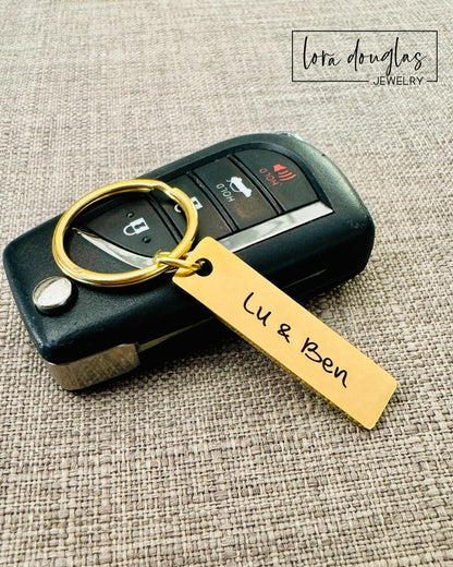 A gold stainless steel keychain with an custom engraved text