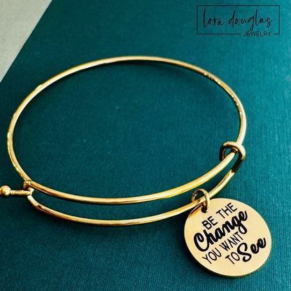 engraved be the change charm necklace stainless steel round pendant with inspirational quote on minimal jewelry piece shown close up with polished finish and clean engraving detail suitable for everyday wear or gift