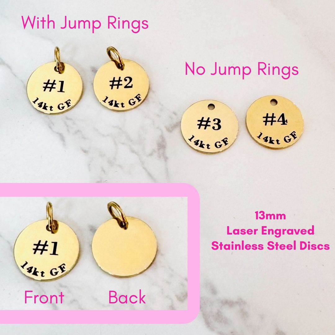 Four round, gold-colored stainless steel discs by Lora Douglas Jewelry are shown—two with jump rings and two without. These 13mm Permanent Jewelry ID Tags for Displays are laser engraved for durability (chains not included).