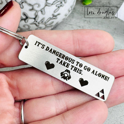 Close up of engraved stainless steel keychain showing Triforce cutout detail and permanent laser engraving on brushed metal surface.