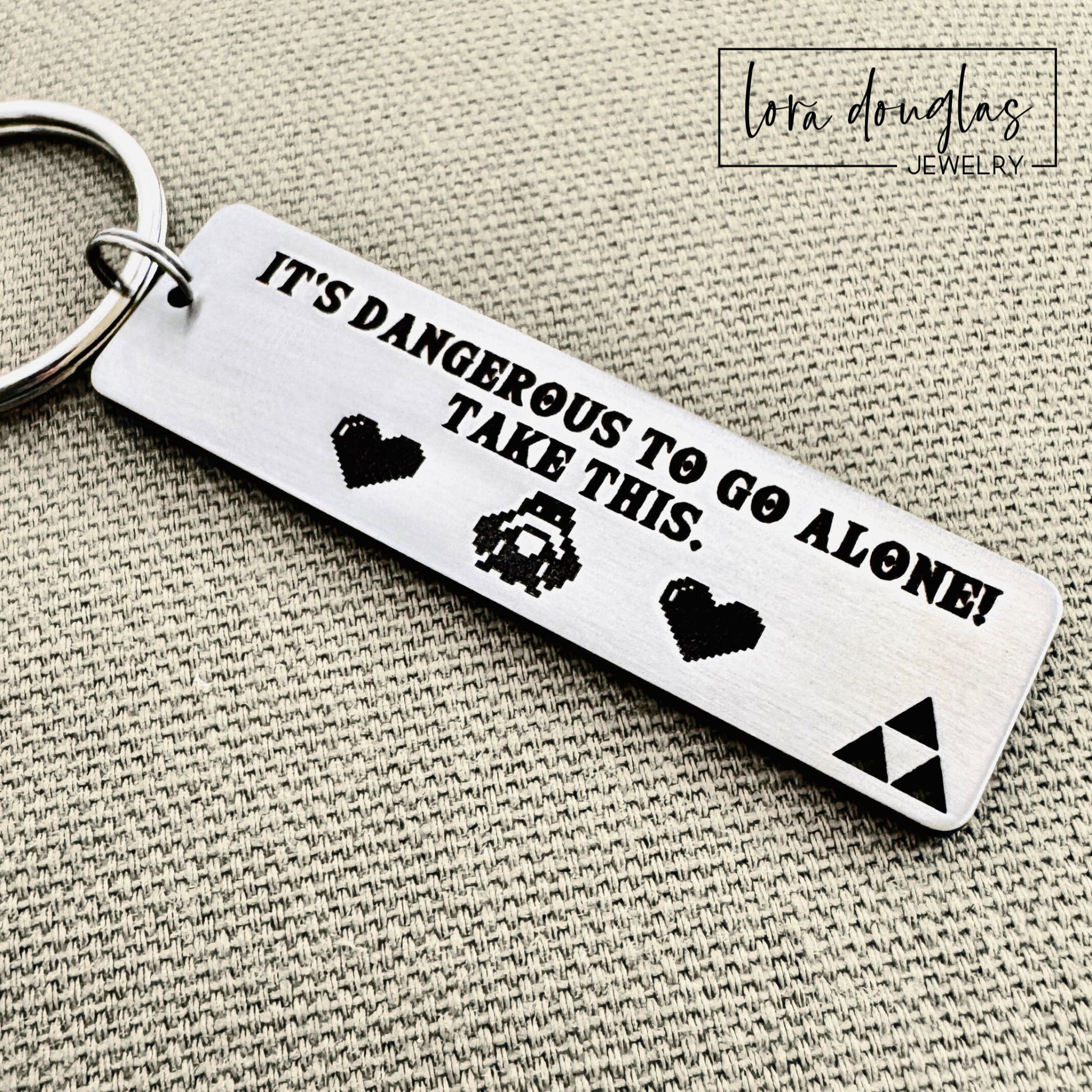 Engraved stainless steel gamer keychain featuring Triforce inspired cutout design and custom engraved message displayed with keys, designed as personalized video game fan gift.