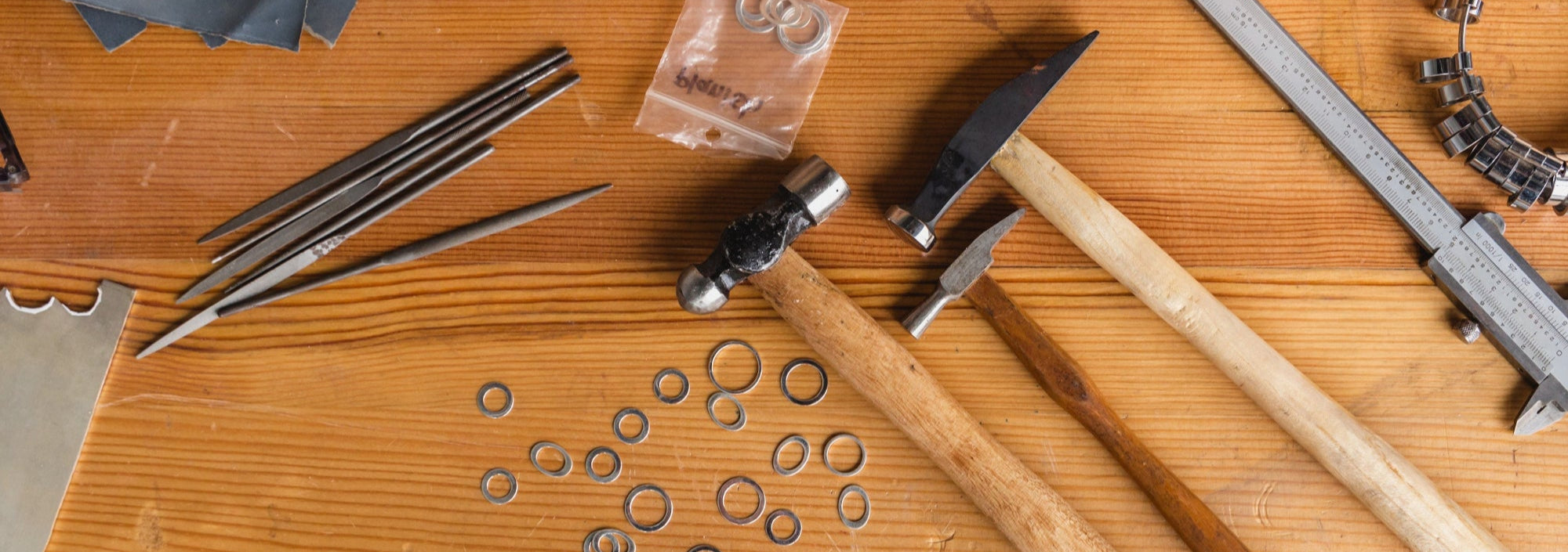 Wooden workbench with tools including hammers, pliers, and measuring instruments.