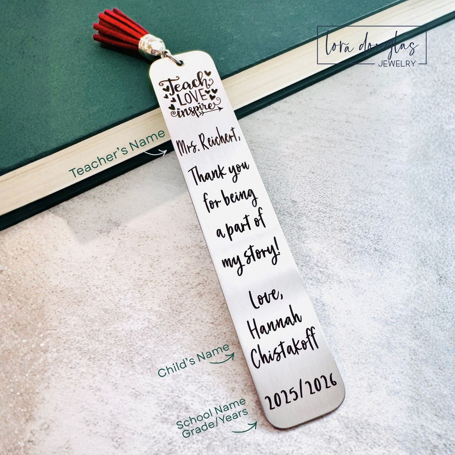 personalized teacher bookmark engraved with teacher name and student name shown resting inside a book with navy tassel visible, stainless steel brushed finish with dark laser engraving, meaningful end of year teacher appreciation gift displayed in natural light