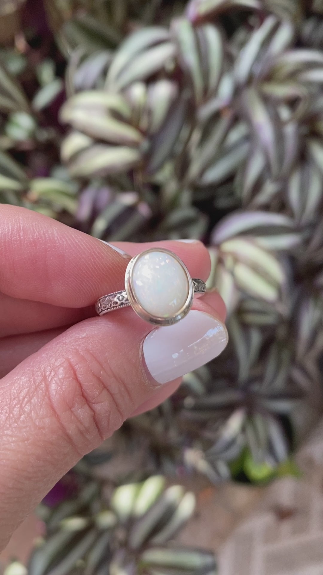 A sterling silver ring with a hand-cut opal cabochon centerpiece, set in an oval setting.